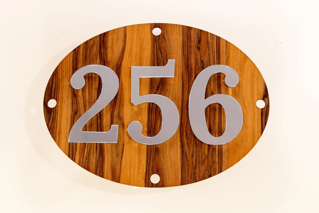 Neutraal Luxe ovaal huisnummerbord zonder LED met Satin Walnut Nocino Red Gum fineer en zilveren spiegelcijfers.