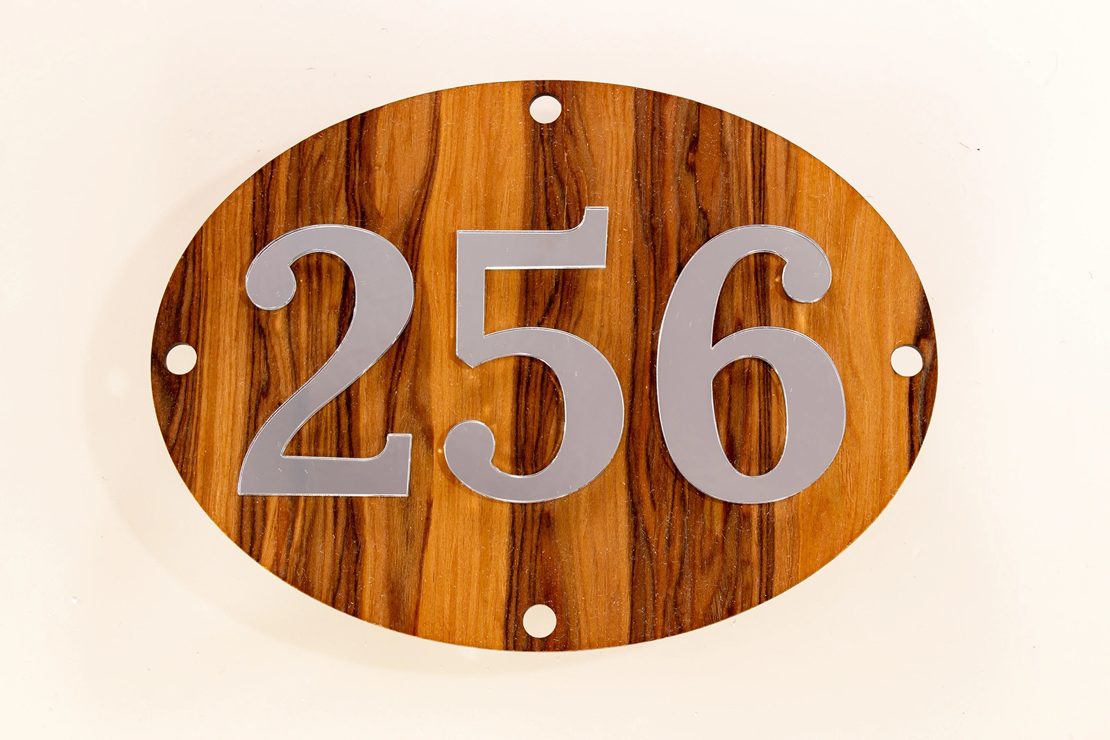 Neutraal Luxe ovaal huisnummerbord zonder LED met Satin Walnut Nocino Red Gum fineer en zilveren spiegelcijfers.